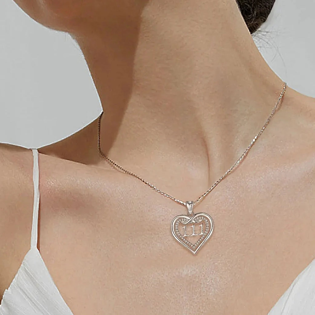 111 infinity heart necklace worn on the neck with a clear CZ stone-lined inner heart