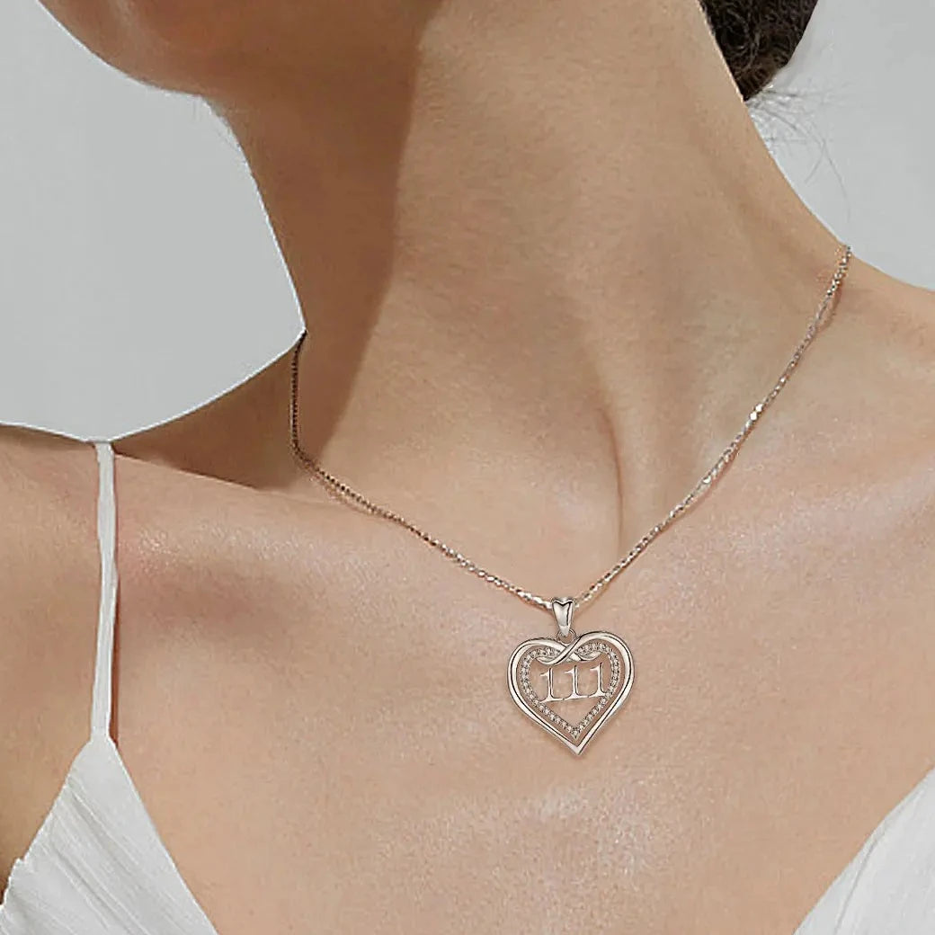 111 infinity heart necklace worn on the neck with a clear CZ stone-lined inner heart