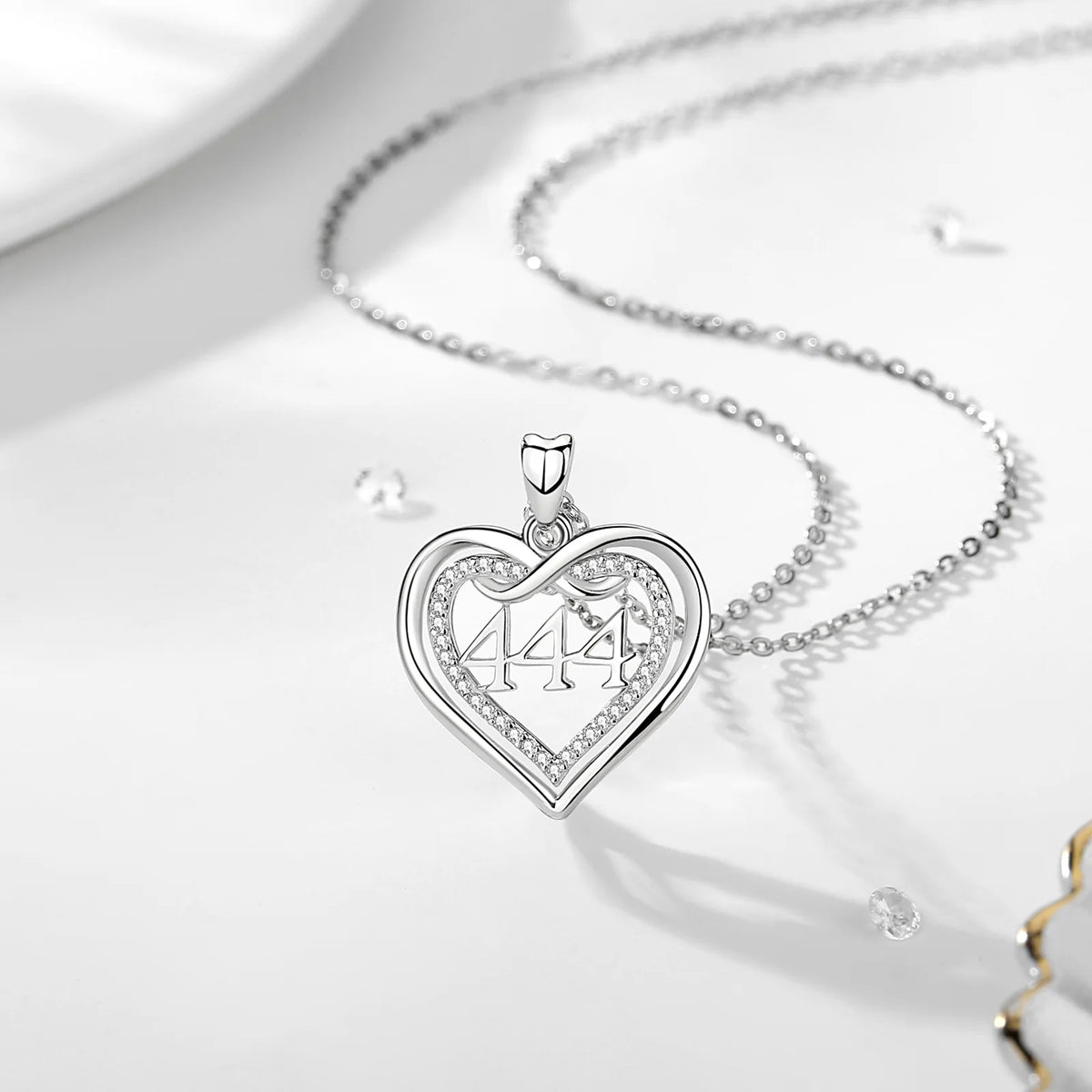 444 angel number heart pendant on a silver chain, shown on a white surface