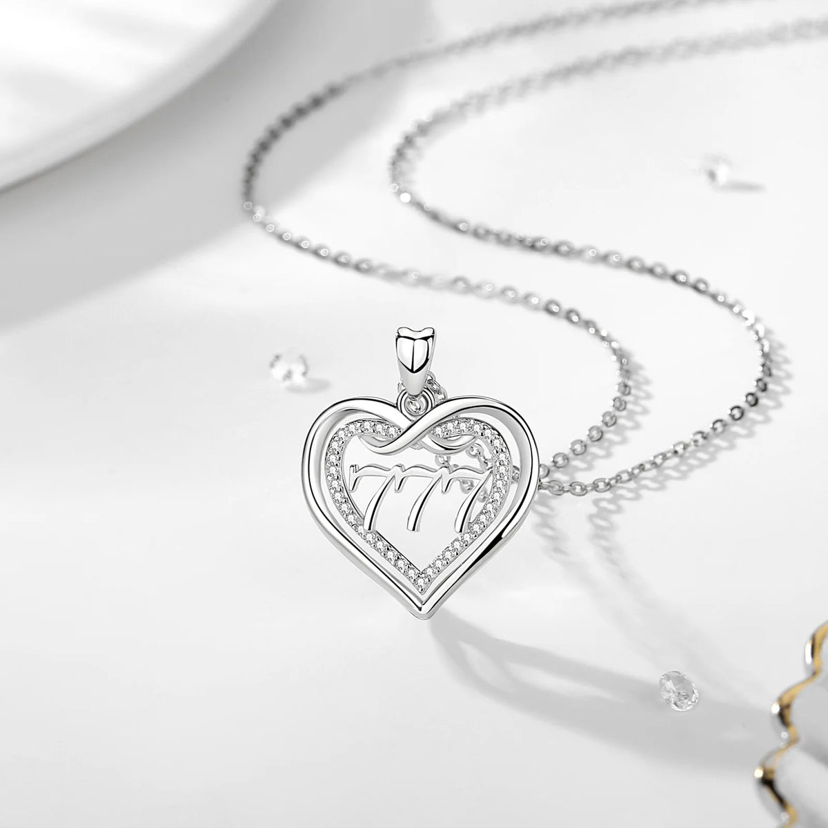 777 angel number heart necklace centered on a white display surface with its chain