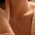 925 sterling silver heart necklace worn with a knit top, showing the beaded edge and radiating center