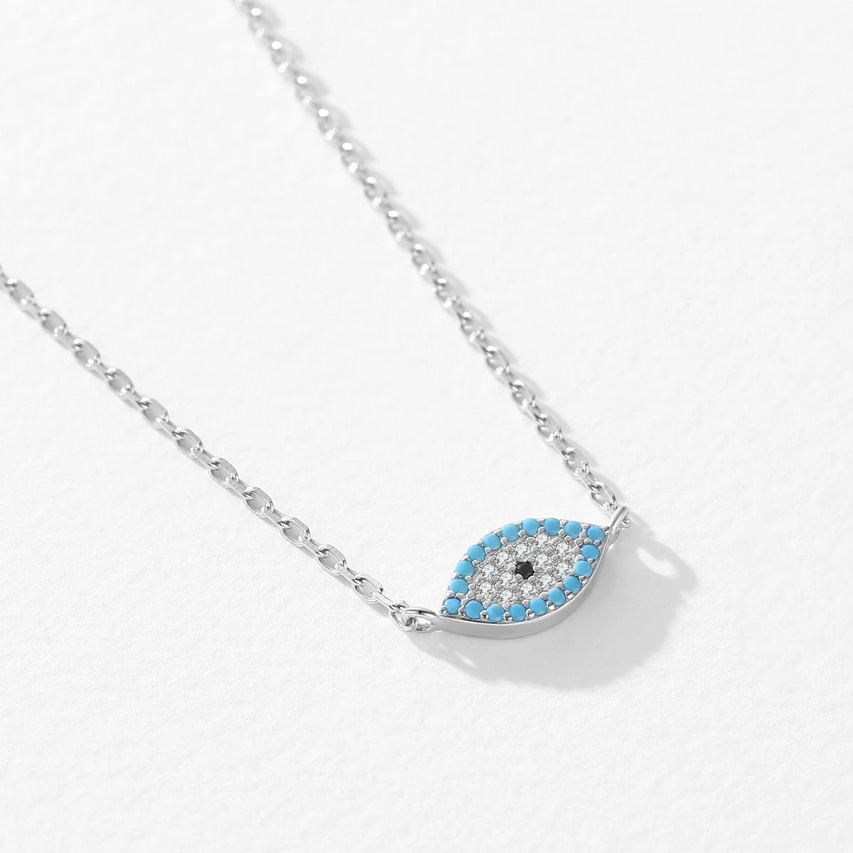 Angled view of the blue-bordered evil eye motif joined directly to elongated oval chain links