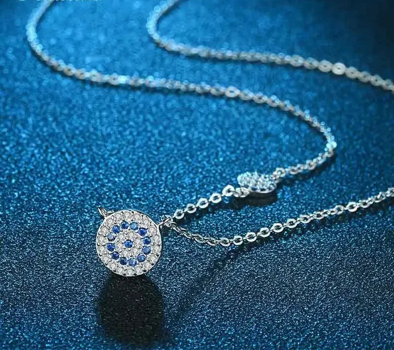 Close-up of the silver-tone necklace with a round blue and clear cubic zirconia evil eye medallion