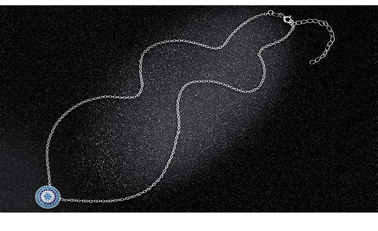 Silver-colored oval-link necklace with blue round evil eye pendant on black background