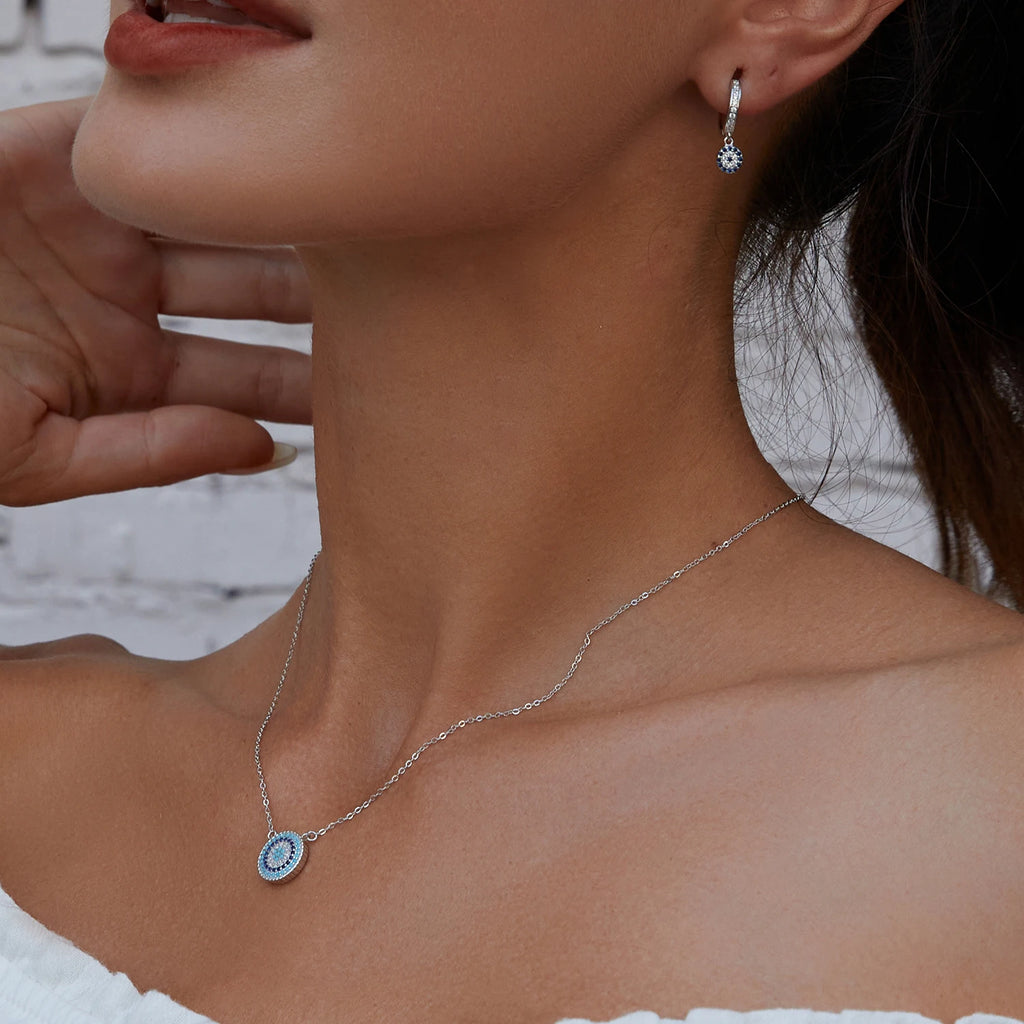 Blue stone evil eye pendant necklace worn high on the neck in a close-up view