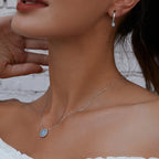 Blue stone evil eye pendant necklace worn high on the neck in a close-up view