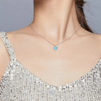 Platinum-plated 925 sterling silver blue heart necklace worn just below the collarbone