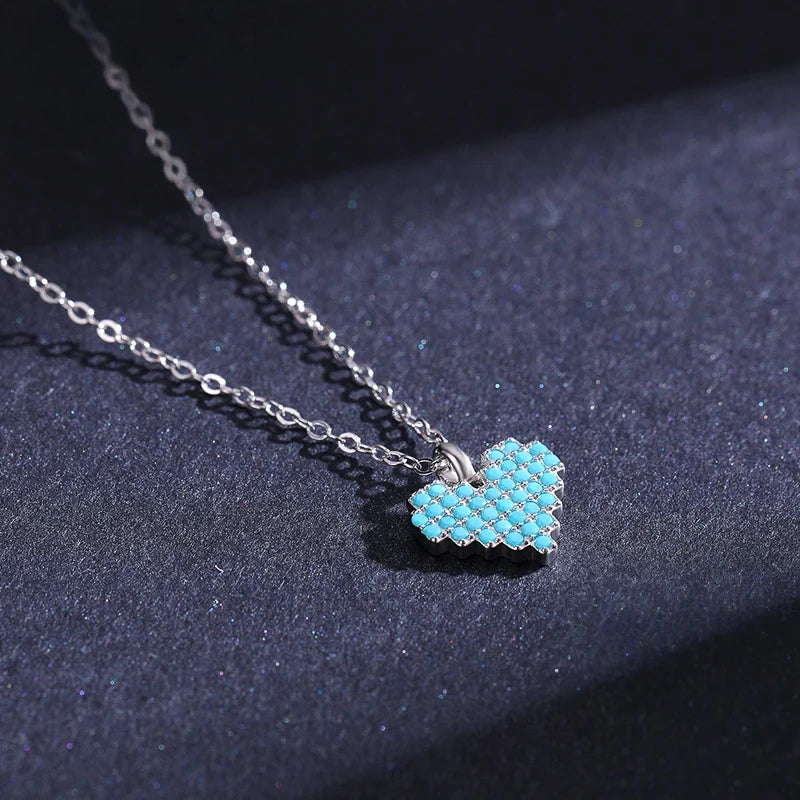 Side angle of the light-blue stone heart pendant showing its polished bail and oval-link chain