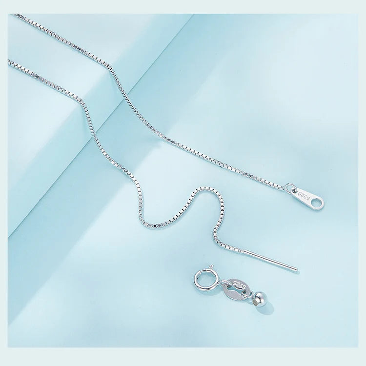 Close-up of the fine box chain clasp and extender components on a pale blue background