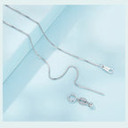 Close-up of the fine box chain clasp and extender components on a pale blue background