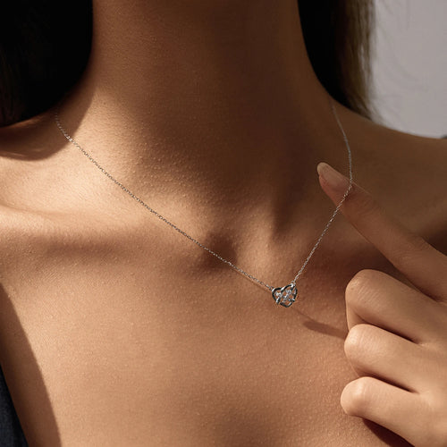 925 sterling silver Celtic heart necklace worn at the collarbone, with a hand beside the pendant