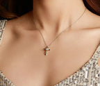 Silver cross necklace with a gold-plated heart ribbon and round moissanite worn at the collarbone
