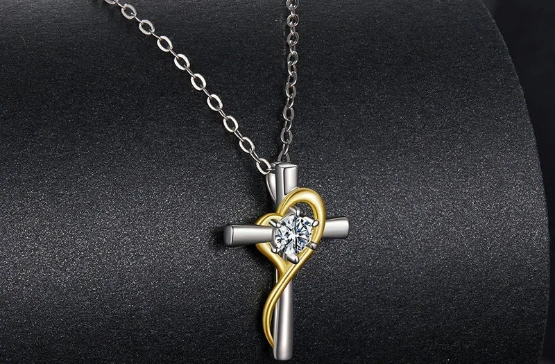 925 sterling silver cross pendant with gold-plated heart ribbon and moissanite on a dark necklace display