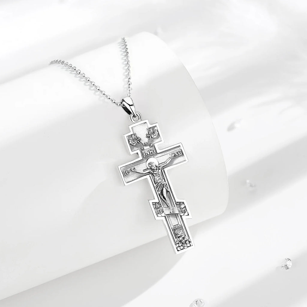 925 sterling silver crucifix necklace displayed on white curved props with textured cross details
