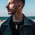 Detailed crucifix necklace worn with a dark shirt and jacket, showing the raised Christ figure