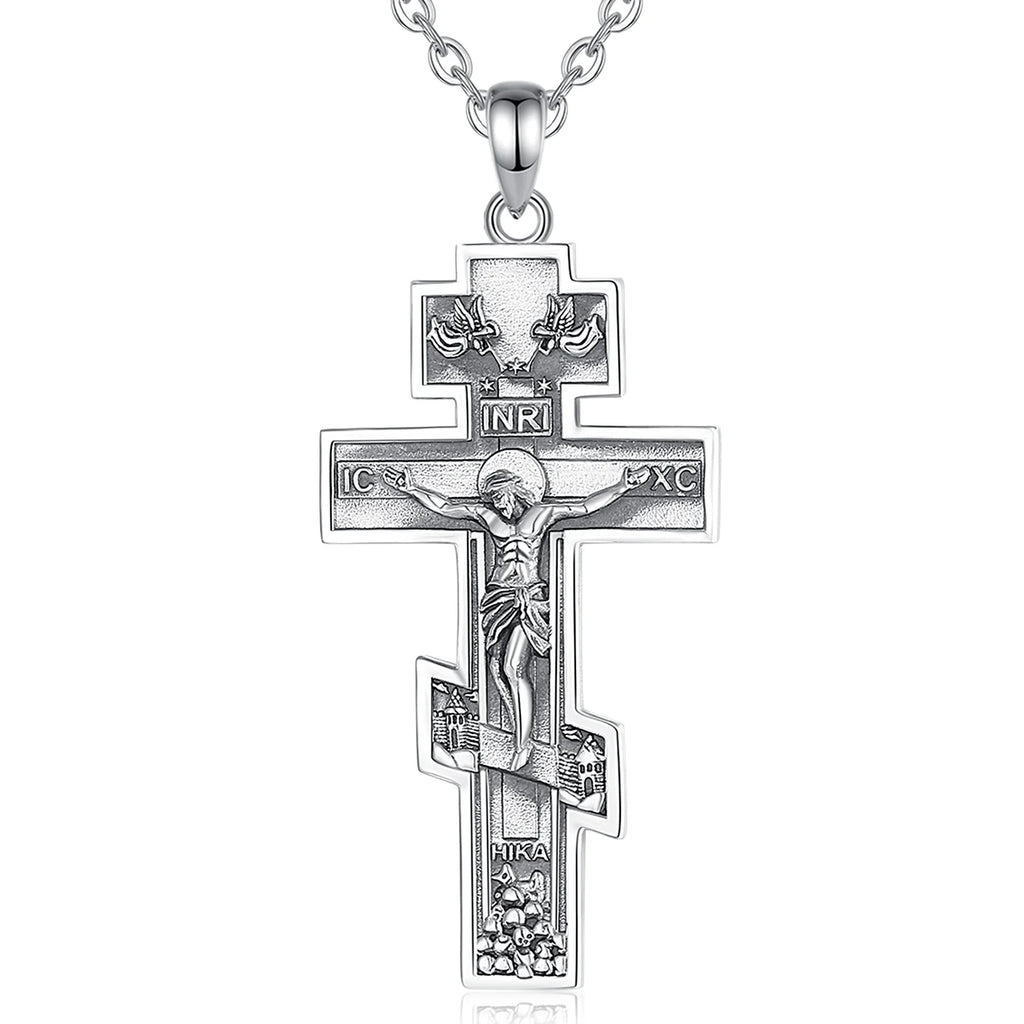 Detailed sterling silver crucifix hanging from a fine silver chain against a white background
