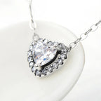 Angled close-up of the crystal halo heart pendant and elongated oval-link chain in sterling silver