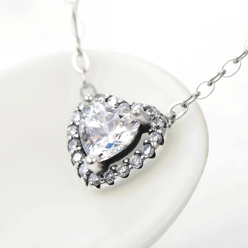 Angled close-up of the crystal halo heart pendant and elongated oval-link chain in sterling silver