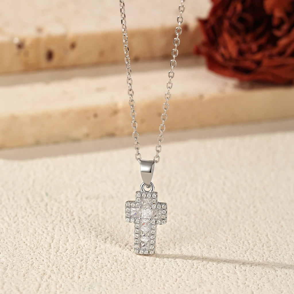 Close-up of 925 sterling silver cross pendant with square CZ stones on an oval-link chain