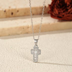 Close-up of 925 sterling silver cross pendant with square CZ stones on an oval-link chain