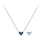 Dark blue CZ heart necklace on a fine silver chain beside a clear heart motif