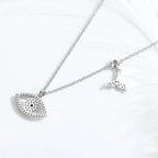 Back view of the whale tail evil eye necklace showing open stone settings and polished silver finish