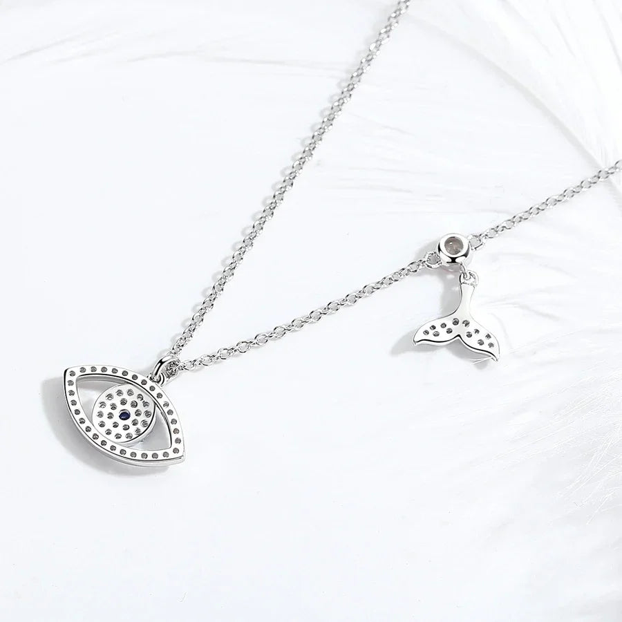 Back view of the whale tail evil eye necklace showing open stone settings and polished silver finish