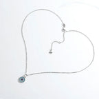 Silver-tone evil eye necklace arranged to show the oval-link chain, extender and lobster clasp
