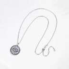 Sterling silver evil eye necklace laid out to show the cable-link chain, lobster clasp, and extender