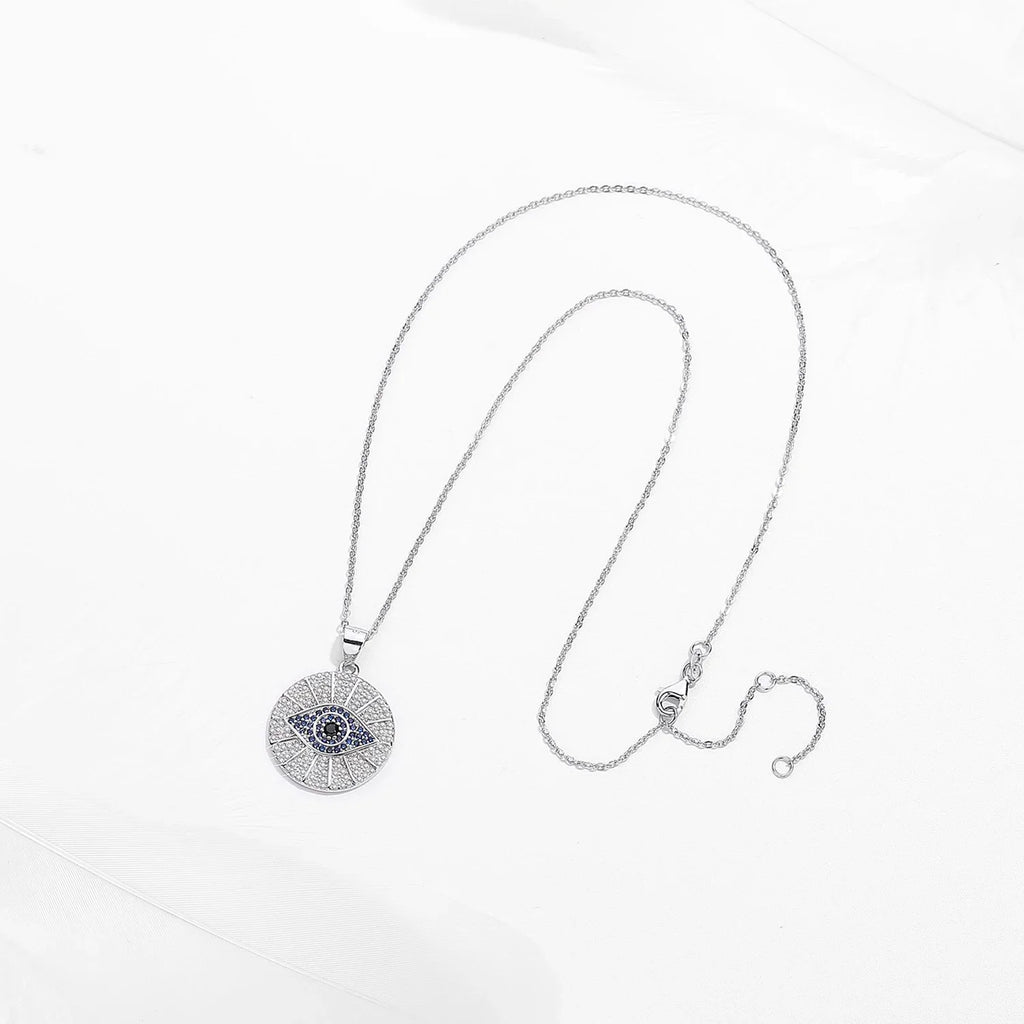 Silver-tone evil eye necklace laid out to show the oval-link chain, clasp, and extender