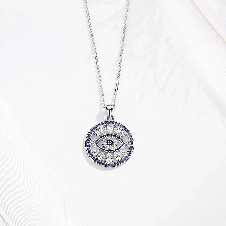 Round evil eye pendant necklace displayed flat with clear and blue cubic zirconia stone details