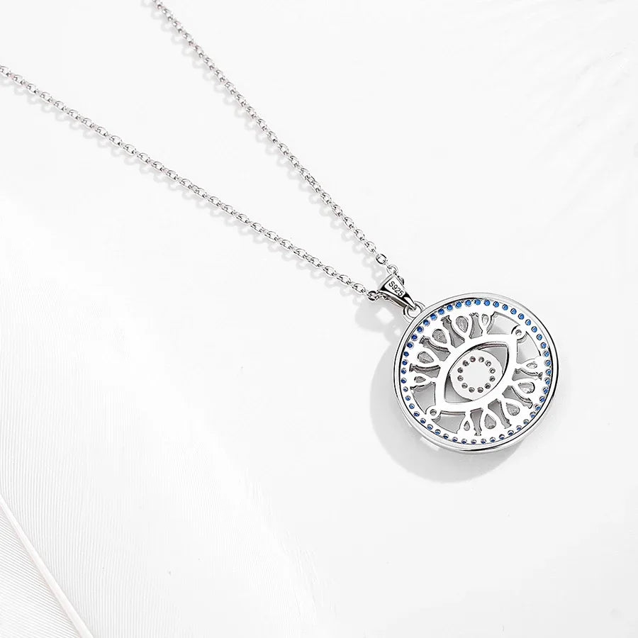Reverse of the sterling silver necklace pendant showing an openwork eye and radiating rays with blue CZ border