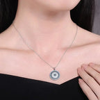 Silver-tone Turkish evil eye necklace worn at the collarbone with a round colorful stone-set pendant