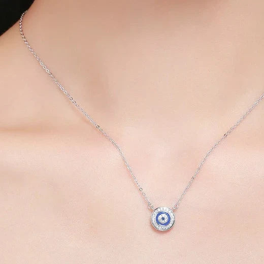 Blue concentric evil eye necklace worn at the base of the neck on a fine silver chain