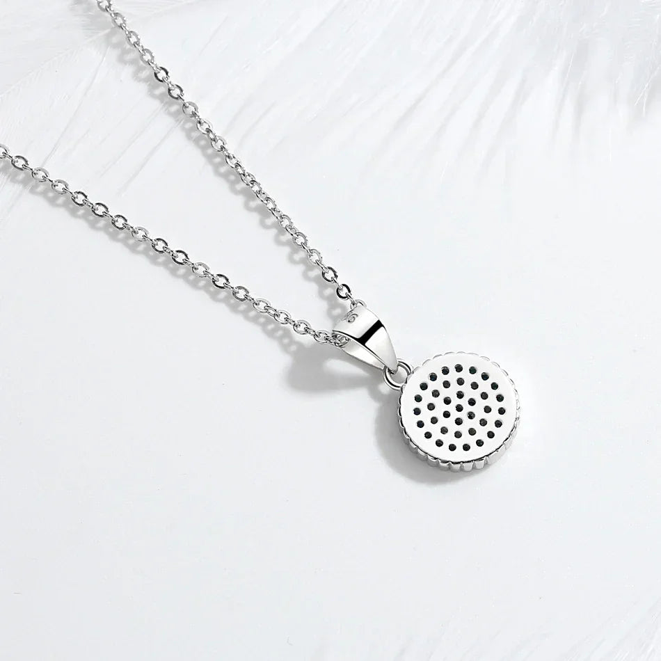 Back view of the round silver-tone evil eye pendant showing perforations behind the stone settings
