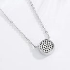 Back view of the silver-tone flower evil eye pendant showing its open perforated pattern