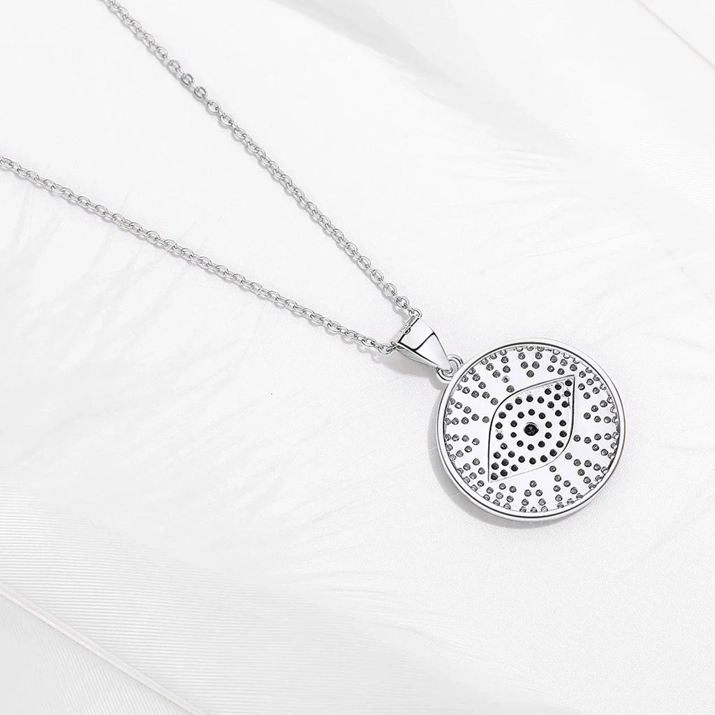 Back view of the silver-tone round evil eye pendant with open perforations behind the stones
