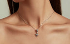 Eye of Horus ankh necklace worn at the collarbone, showing the blue CZ-set bail and silver pendant
