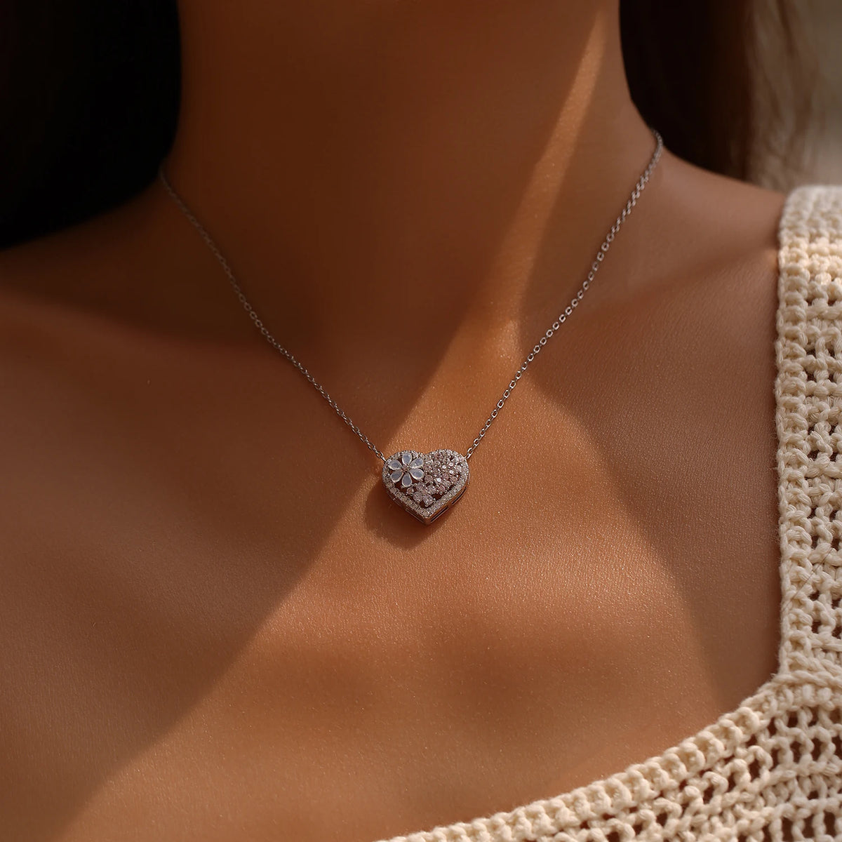 Sterling silver flower heart necklace worn on the neck, showing the pale pink stone cluster and sparkling border