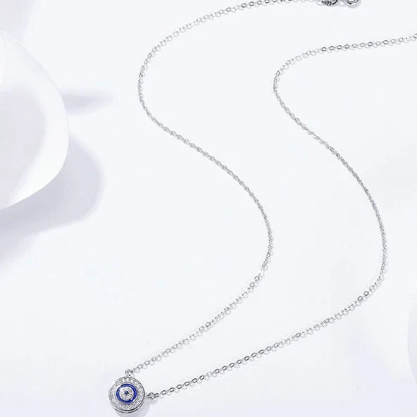 Full-length 925 sterling silver necklace arranged on a white surface with the small blue evil eye pendant