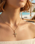 Gold-tone Celtic cross necklace worn on the neck, showing the open heart and clear center stone