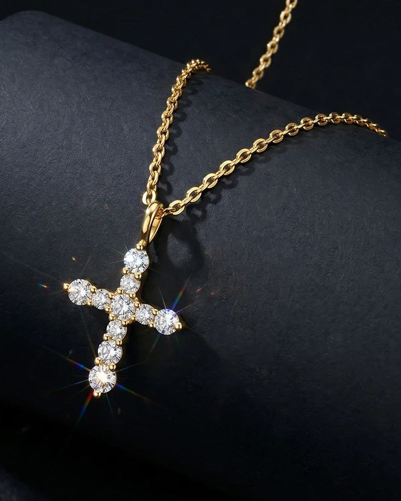 Gold-tone cross necklace with round moissanite stones displayed on a dark sculptural prop