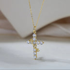 Gold-tone cross pendant with clear cubic zirconia stones and a diagonal thorn-textured band
