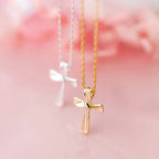 Gold-tone flared-arm cross necklace in focus with a silver-tone cross necklace in the background