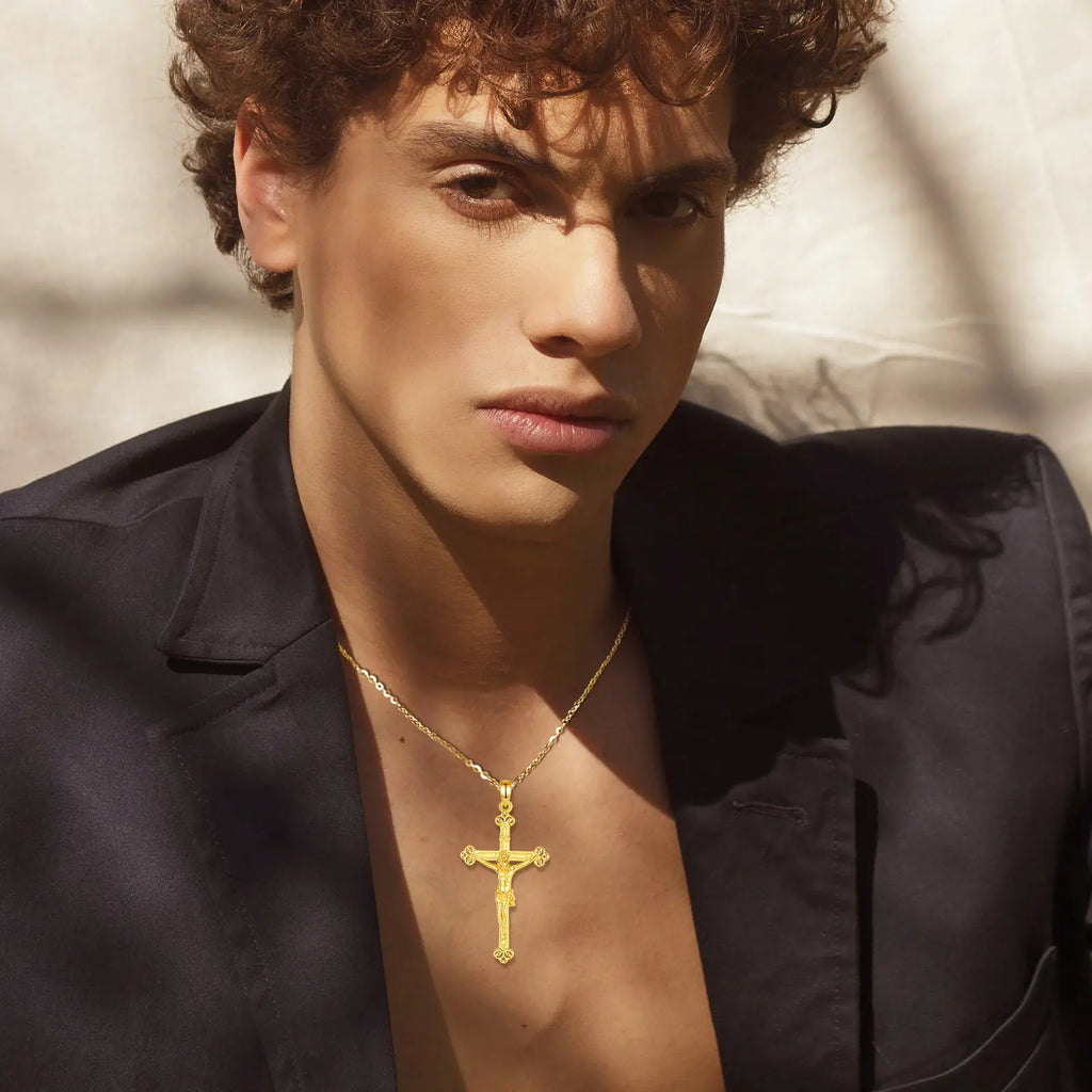 Gold crucifix necklace worn on the neck, with raised Jesus figure and open trefoil cross ends