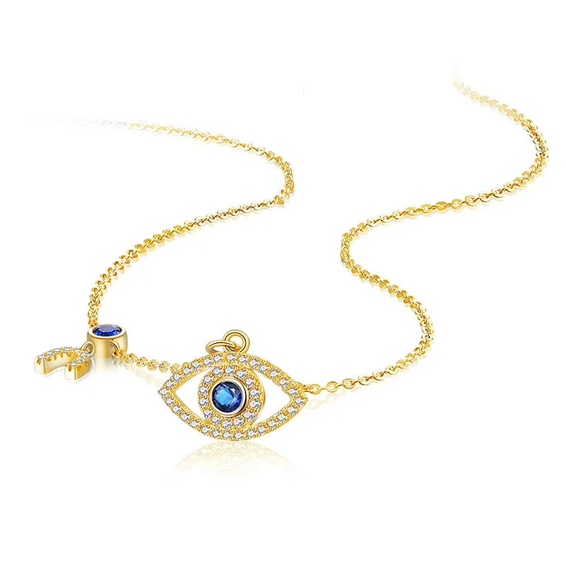 Gold-tone evil eye necklace laid out on white, showing the clear CZ outline and blue center stone