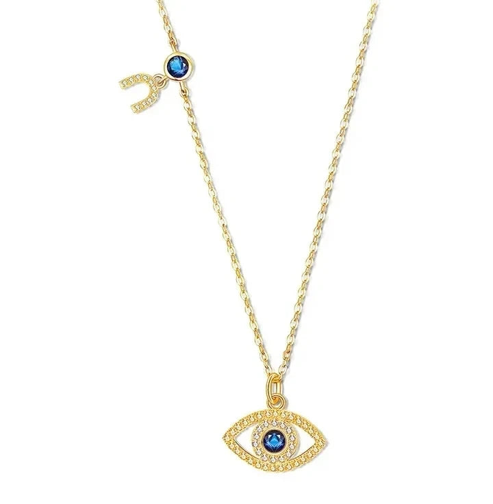 Gold evil eye necklace with blue stone and crescent charm in gold-tone 925 sterling silver on white