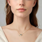 Gold-tone evil eye necklace worn with an off-white top, showing the small blue stone-set pendant at the collarbone