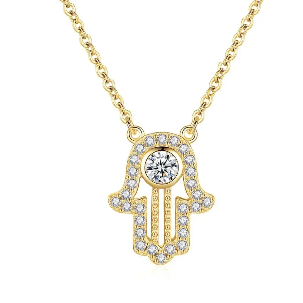 Gold hamsa hand necklace with clear CZ stones, round center stone, and textured beaded palm