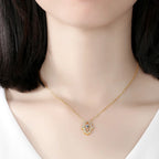 Gold-tone open hamsa hand necklace worn at the collarbone, with clear CZ stones around the outline